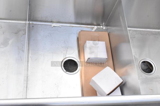 Brand new stainless steel 3 bay sink with visible scratches and dents. Includes drain openings. Ideal for commercial use.