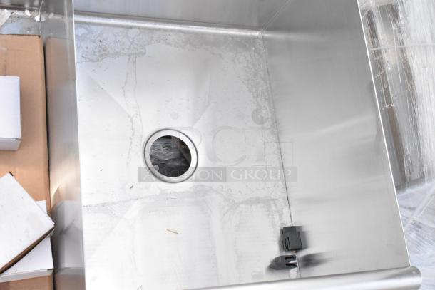 Stainless steel 3 bay sink, brand new with visible scratches and dents. Drain opening featured in one bay.