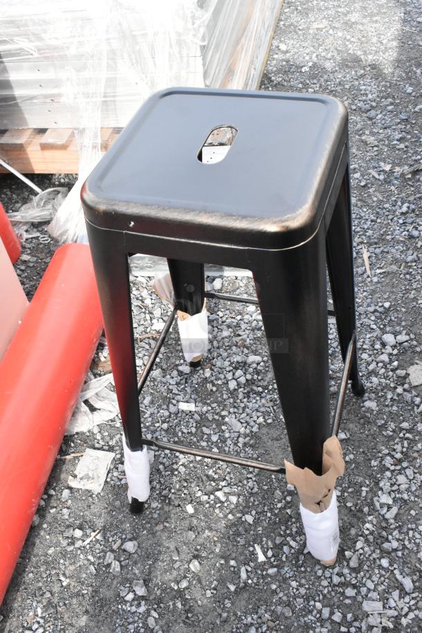 Black metal Tolix style bar stool, new with scratch and dent, protective wrapping on legs, industrial design.