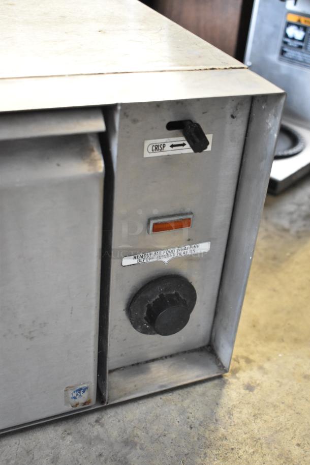 APW Wyott BW-20 metal warming drawer, featuring controls for crispness and heat settings, 120 volts, 1 phase. Visible signs of use.