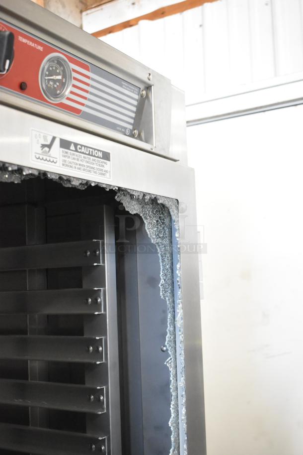 Metro C569-SFC-L heated cabinet, new scratch and dent, with broken glass. Commercial casters, 120V, 1 Phase. Caution label visible.
