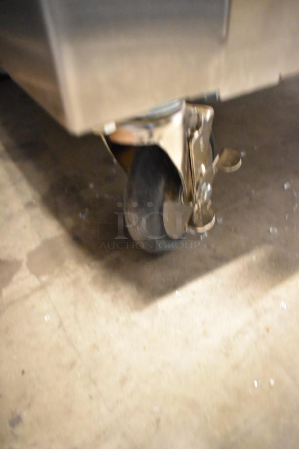 Metro C569-SFC-L heated holding cabinet caster. Note: broken glass visible. New, scratch, and dent condition.