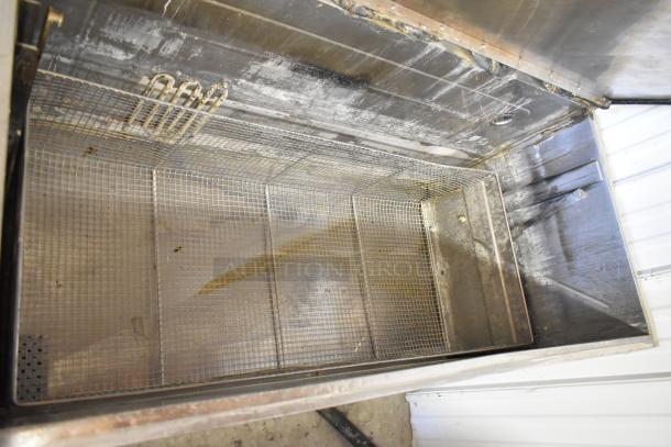 Stainless steel commercial washing bin, floor style, sturdy construction, used condition, visible interior mesh and heating element.
