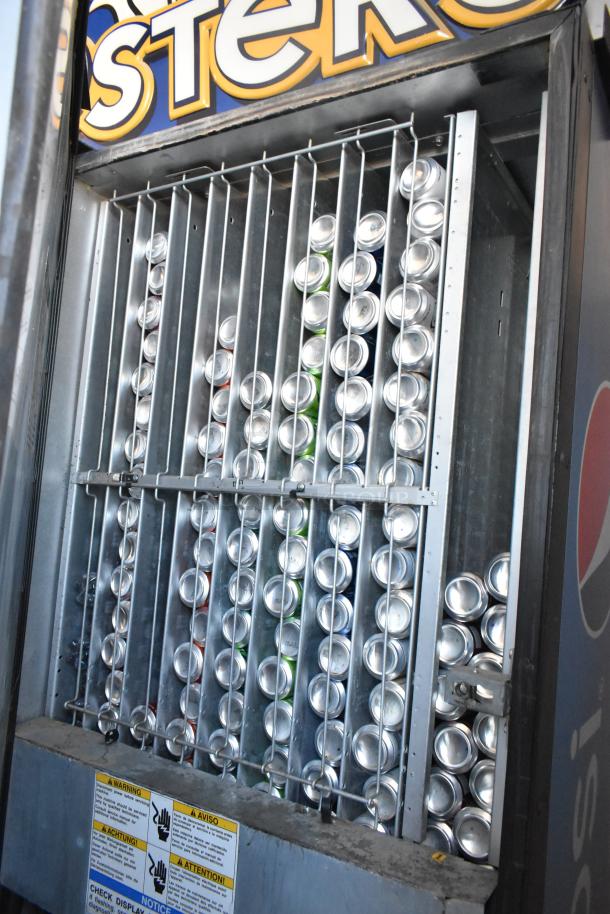 Dixie-Narco DN600E-MC/SII-9 vending machine filled with cans, credit card acceptor, includes safety warning label.