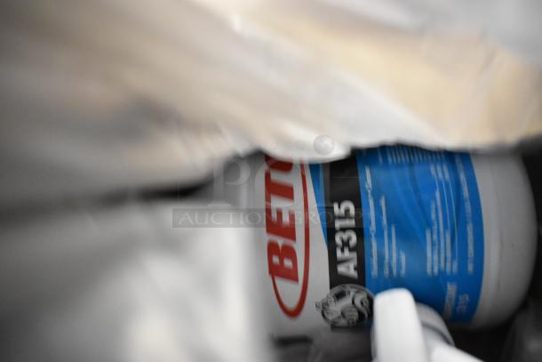 Container of Betco AF315 Disinfectant Cleaner with citrus floral scent, partially visible in a bundle of seven various items.