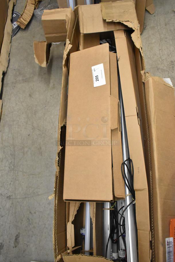 Box of fluorescent light fixtures, open, showing cables and metal components. Label reads "205." Damaged cardboard packaging.
