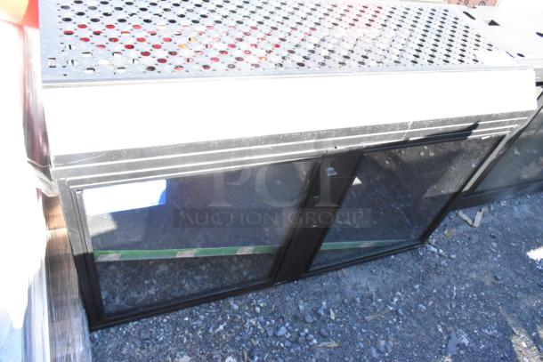 Metal 2 Door Cabinet with glass doors and perforated metal top, shown outdoors on gravel.