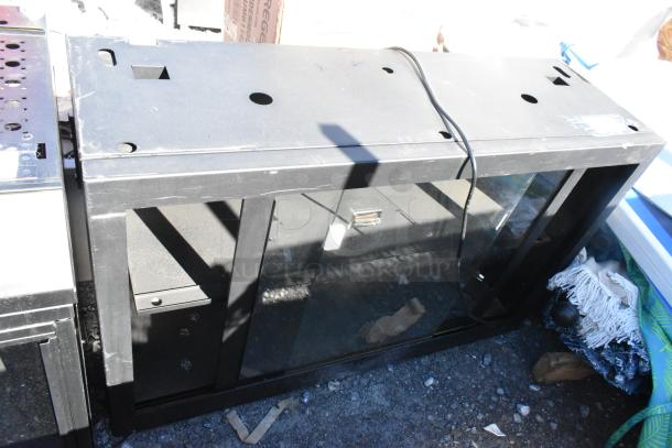 Metal 2 Door Cabinet with glass front, black finish, visible wear and scratches, vent holes on top. Suitable for storage or display.