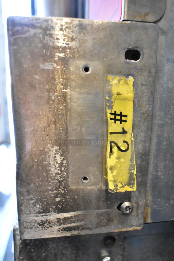 Close-up of scratched metal surface with a yellow tag labeled "#12" on Vulcan convection oven.