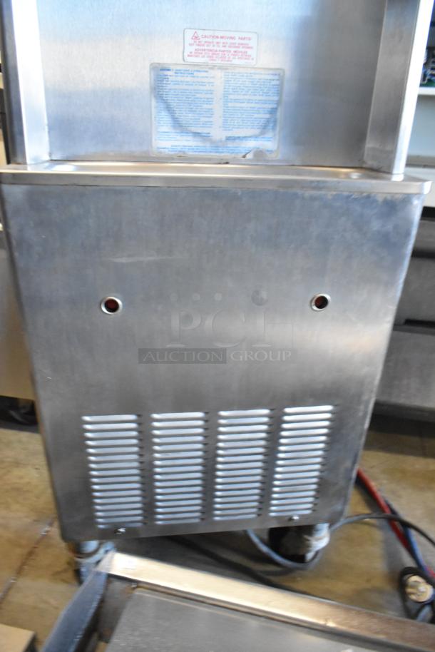 Taylor stainless steel water-cooled soft serve machine with 2 flavors, twist option, and commercial casters. 208/240V, 3 phase.