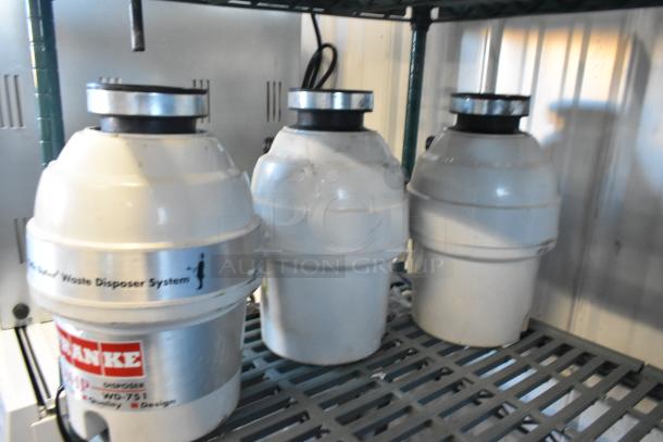Three Franke Little Butler waste disposer systems, 115 volts, 1 phase, shown on a metal shelf. Each unit is white with visible brand marking.