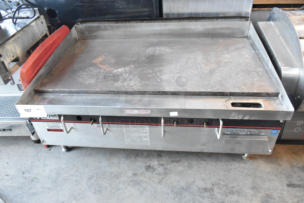 APW Wyott stainless steel commercial gas flat top griddle, used, visible controls, safety labels, countertop style.