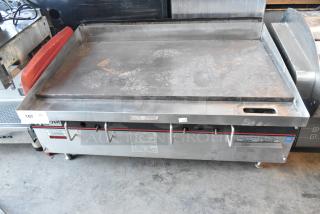 APW Wyott stainless steel commercial gas flat top griddle, used, visible controls, safety labels, countertop style.