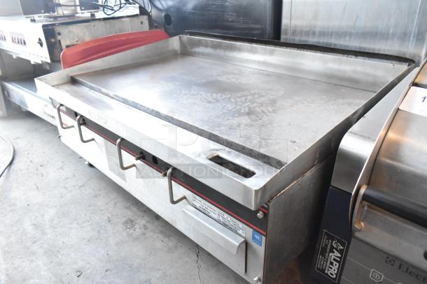 APW Wyott stainless steel commercial countertop natural gas flat top griddle. Used condition with visible controls and labels.