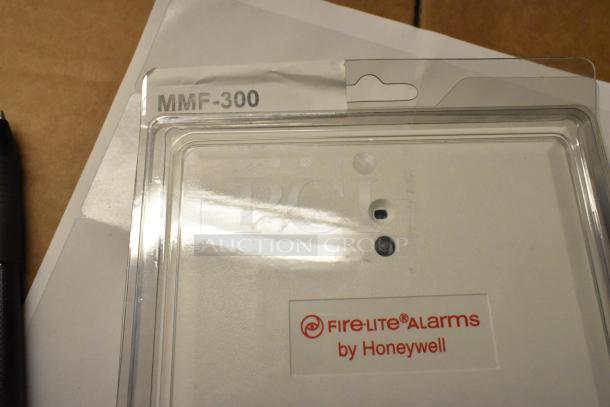 10 brand new Fire Alarm Pull Down Boxes, including models BG-12LX, SD365, MMF-300. Each box features Fire-Lite Alarms by Honeywell branding. Clear packaging with model labels.