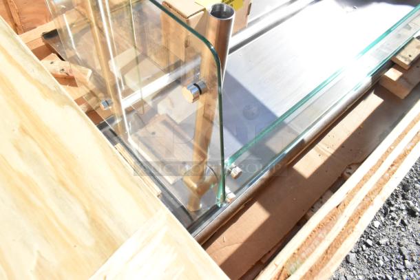 Brand new sneeze guard with minor scratches and dents. Glass panels with metal supports, still in original packaging.