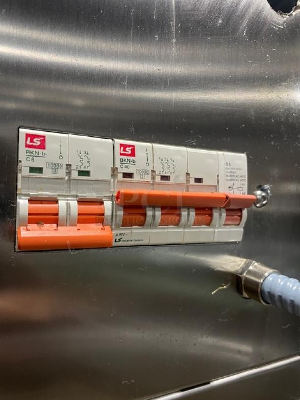 Alt text: Close-up of control panel on Doyon 2T3 electric oven, showing LS circuit breakers and orange switches.