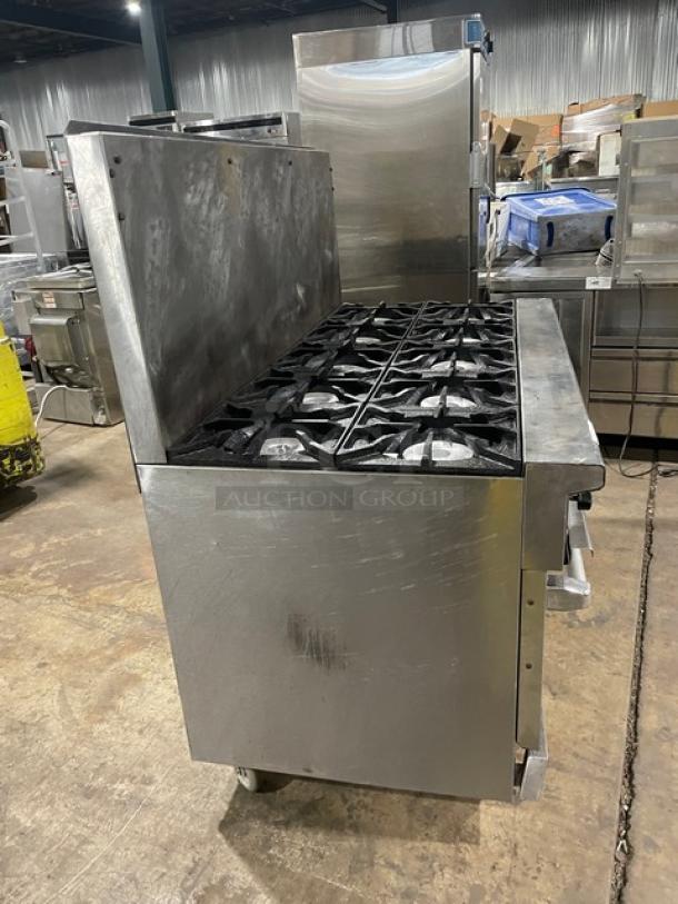 Therma Tek stainless steel 10-burner range with double oven, natural gas powered, wired racks, backsplash, on casters.