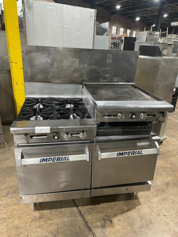 Imperial commercial stainless steel range with 4 burners, raised flat griddle, double oven, broiler, backsplash, and wired racks.