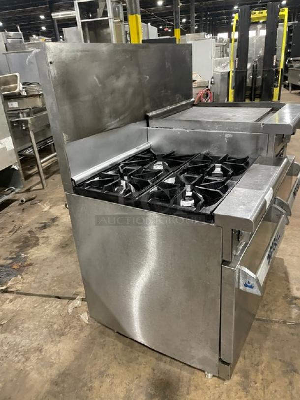 Imperial commercial stainless steel gas range with 4 burners, flat griddle, double oven, broiler, backsplash, and wired racks.