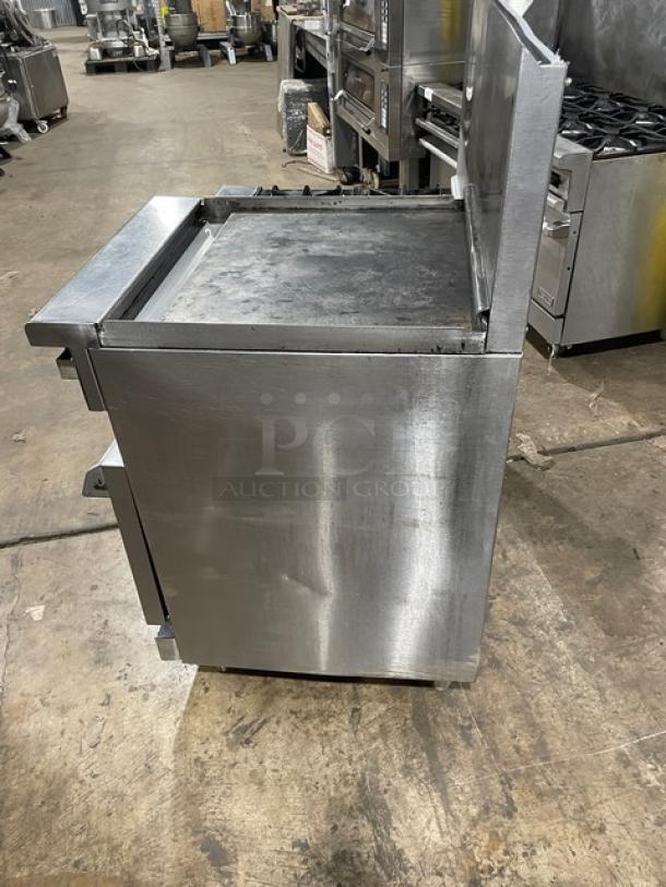 Imperial stainless steel 4-burner range with raised flat griddle, broiler, double oven, backsplash, and wired oven racks.