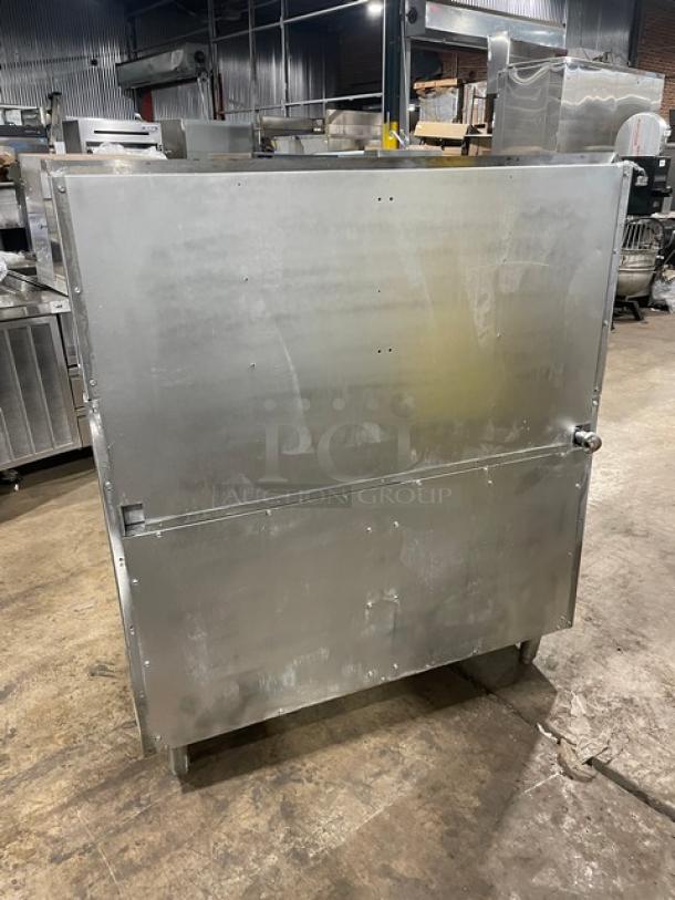 Imperial stainless steel natural gas 4-burner range with raised griddle, double oven, broiler, back splash, and wired racks.