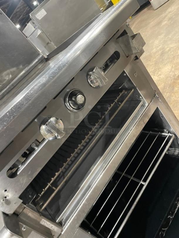 Imperial commercial stainless steel 4-burner range with raised griddle, double oven, broiler, and back splash. Wired racks included.