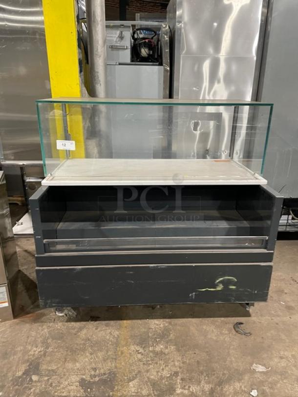 Structural Concepts commercial black refrigerated grab-n-go display case with upper glass showcase, on legs. Good condition.
