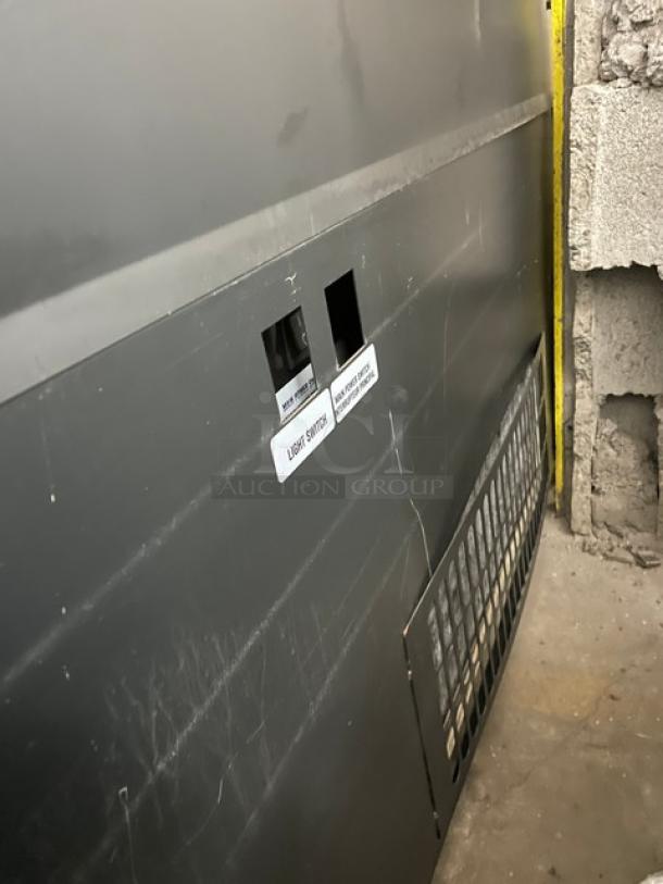 Structural Concepts black multi-level refrigerated display case; shows light switch label and vent, suitable for grab-n-go merchandise.