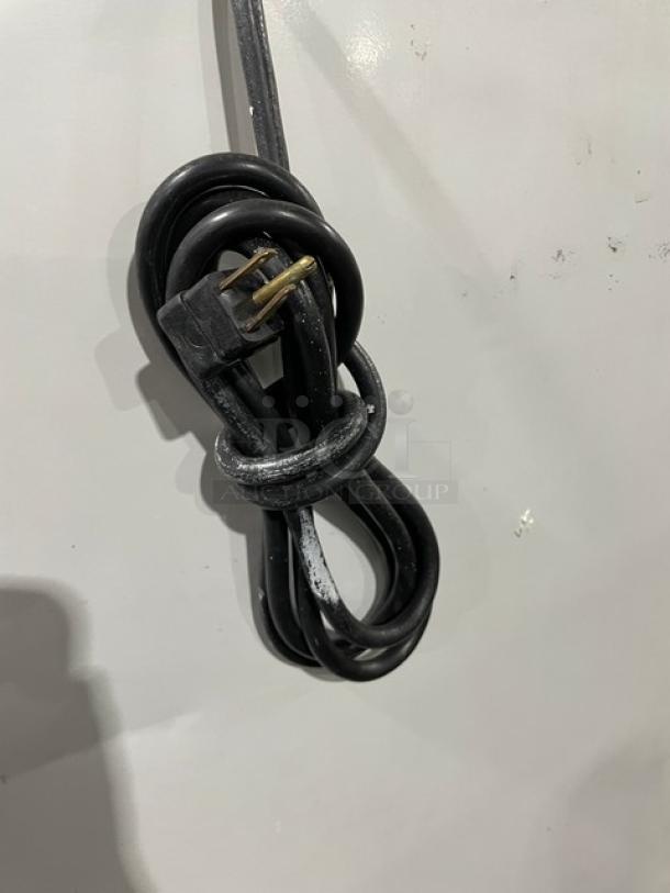 Power cord for Leer Commercial Ice Merchandiser Freezer, Model 301UC25MG, 115V, shown coiled against the white exterior.