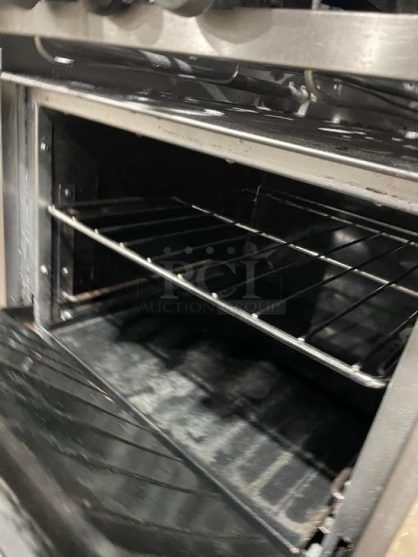 Sunfire stainless steel 4-burner range/oven combo with backsplash, overhead shelf, and wired oven rack. Natural gas-powered.