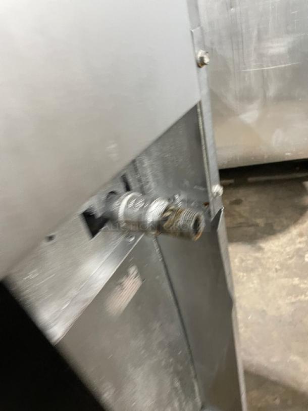 Sunfire commercial stainless steel natural gas powered range/oven combo in used condition with visible connection pipe.