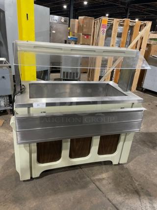 Stainless steel portable salad bar with sneeze guard, folding tray slide, and casters. Ideal for commercial use.