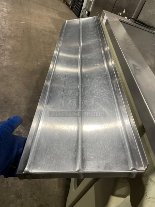 Commercial stainless steel refrigerated salad bar with sneeze guard, folding tray slide, and casters.