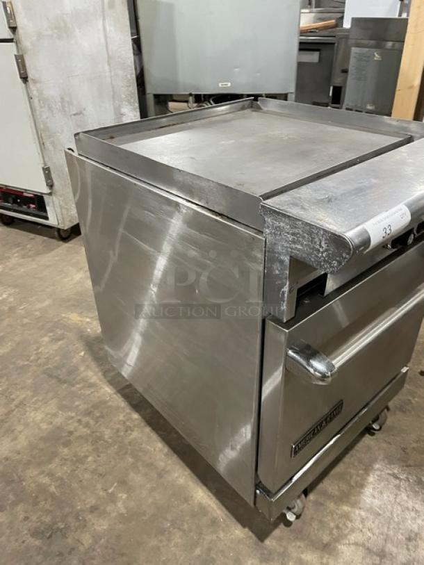 American Range 24" stainless steel flat-top range/oven combo, natural gas, with wired oven rack, on casters. Slight wear.