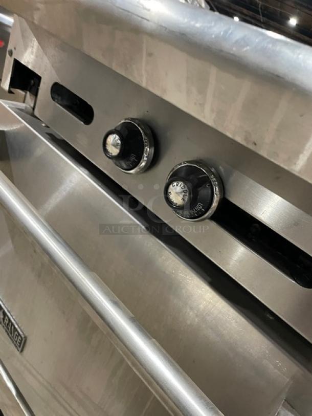 American Range stainless steel 24" flat-top range/oven combo, natural gas, wired oven rack, on casters, control knobs shown.