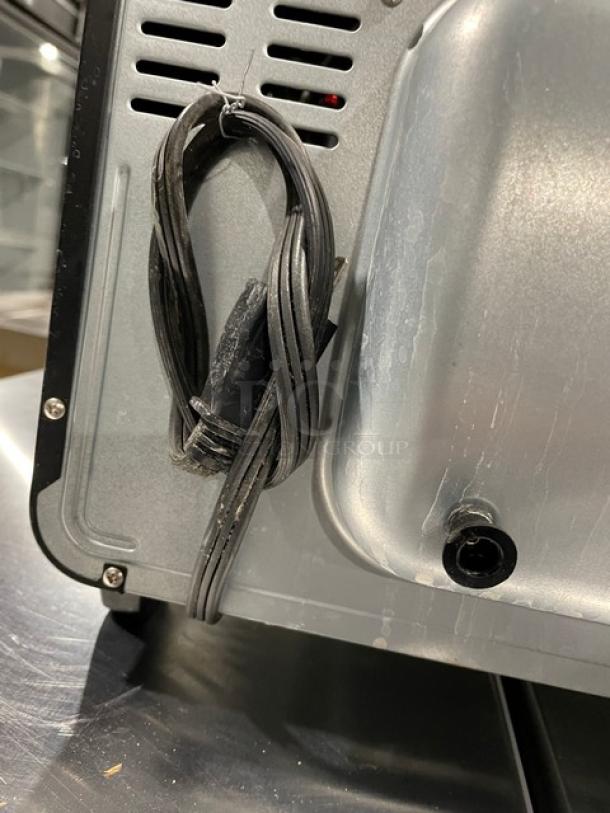 BLACK+DECKER TO3250XSB toaster oven rear view, showing power cord and ventilation. Stainless steel in good condition.
