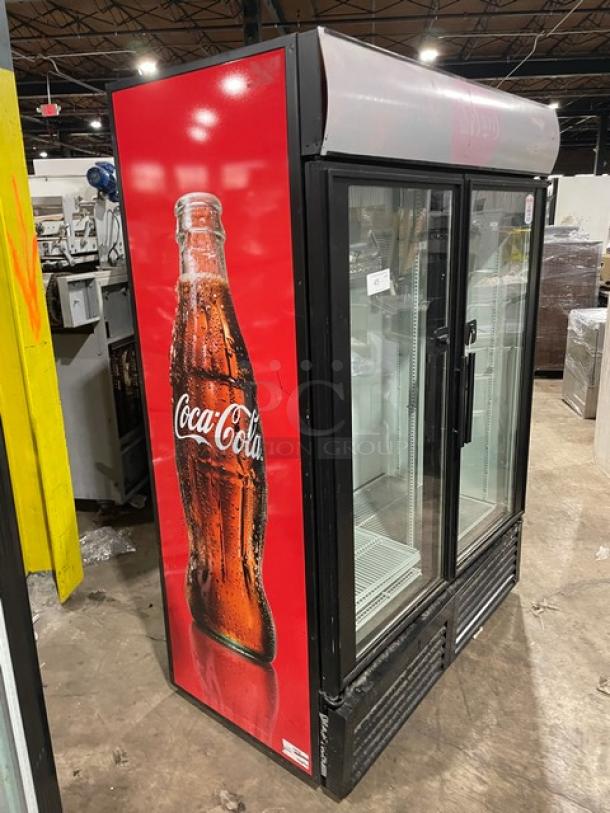 True GDM-49 commercial refrigerator with black double glass swing doors. Features a Coca-Cola design and poly-coated wire rack.