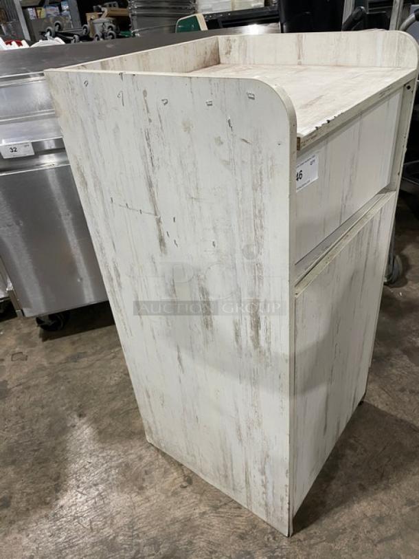 Commercial wooden enclosed trash cabinet, distressed white finish, upright rectangular design, good condition.
