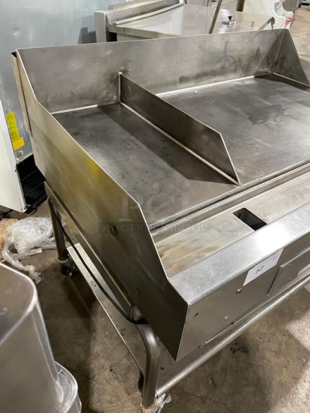 WoodStone stainless steel 48" natural gas plancha griddle with back and side splash, on rolling cart with undershelf.