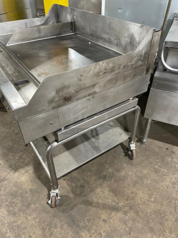 WoodStone 48" stainless steel natural gas plancha griddle with back and side splash, on a caster-equipped undershelf cart.