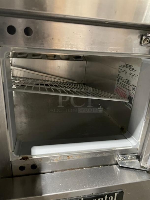 Continental RA93N30M refrigerated prep table, stainless steel, open view with poly-coated wire rack, some wear visible.