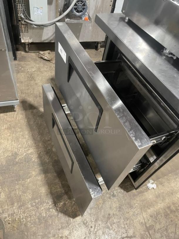 True stainless steel 2-drawer worktop refrigerator, model TWT-27D-2-HC, with upturned backsplash and visible serial label.