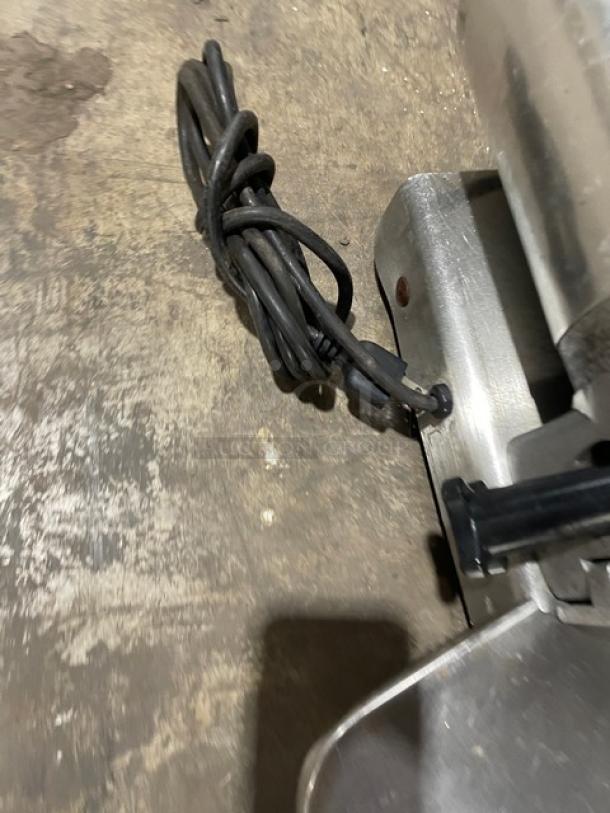 Globe 500L commercial countertop meat slicer, electric-powered, heavy-duty, shown on legs with attached power cord.