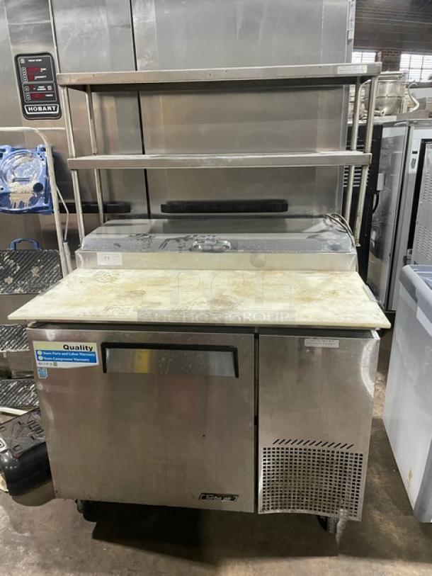 Turbo Air Super Deluxe Series refrigerated pizza prep table, model TPR-44SD, stainless steel, with cutting board, double shelf, and casters.