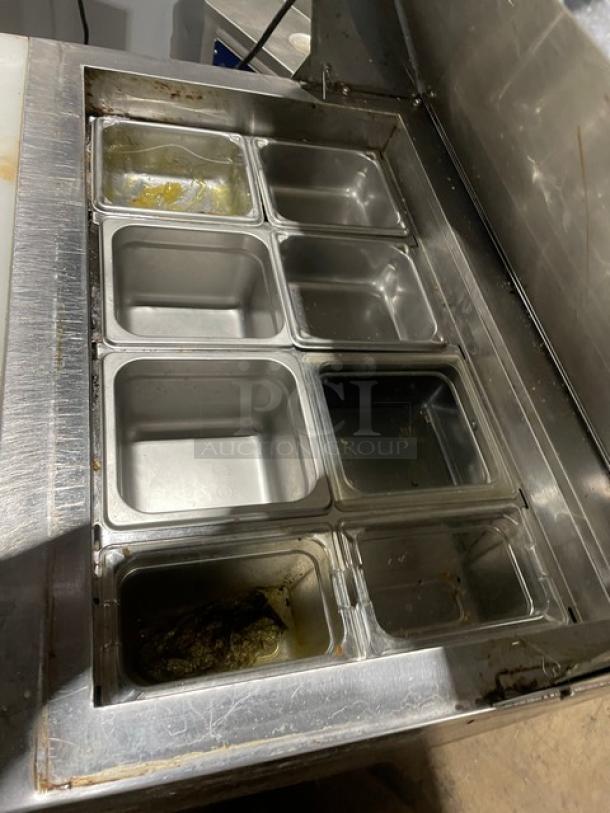 Avantco SCL Series refrigerated prep table with stainless steel pans. Includes cutting board, poly-coated rack, and casters.