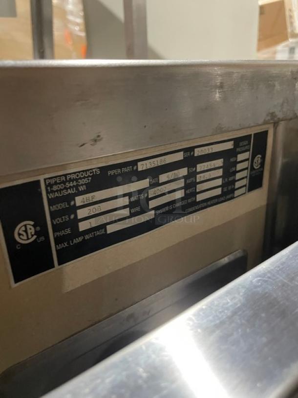 Piper Products stainless steel heated buffet counter, model 4HF, with sneeze guard, tray slides, and enclosed shelf.