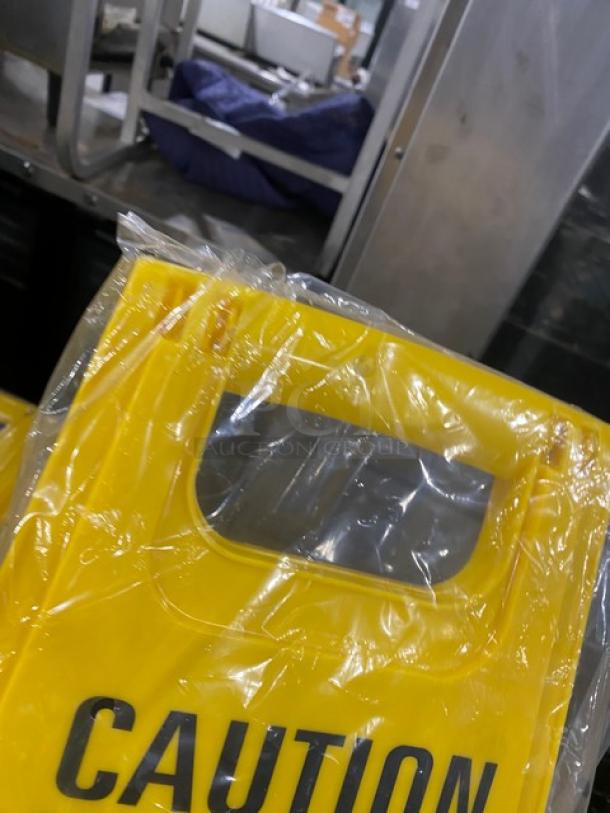 Brand new Update International yellow caution/wet floor sign, fold-out style, Model WFS-25, in original packaging.
