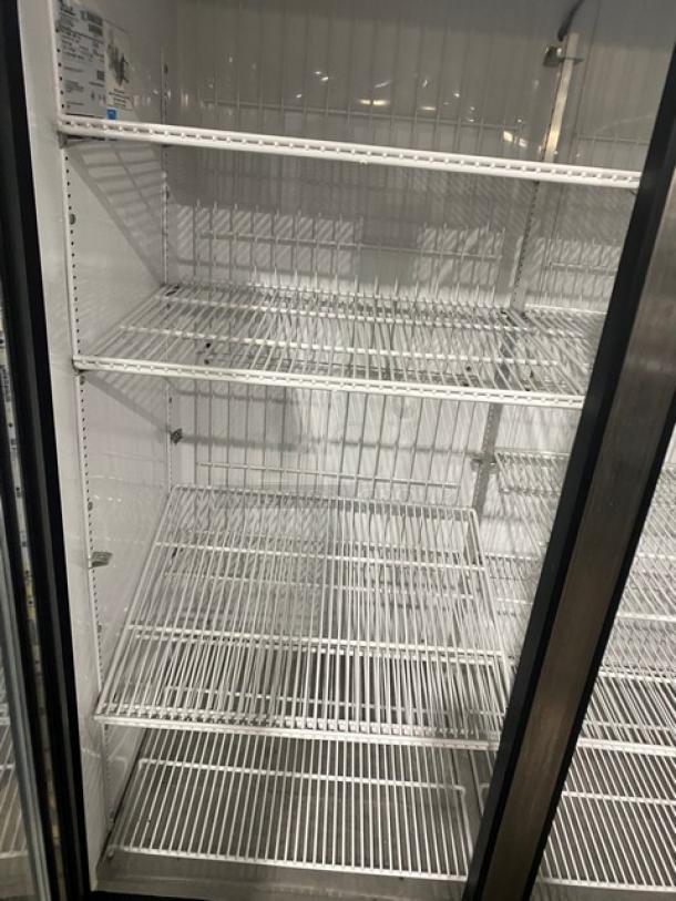 True GDM49FLD commercial freezer, black double glass swing doors, energy-efficient, poly-coated wired racks, on casters.