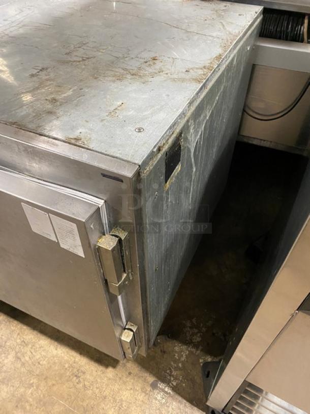 Traulsen UC1LT commercial stainless steel undercounter freezer with chrome-plated rack. Visible wear on surface.